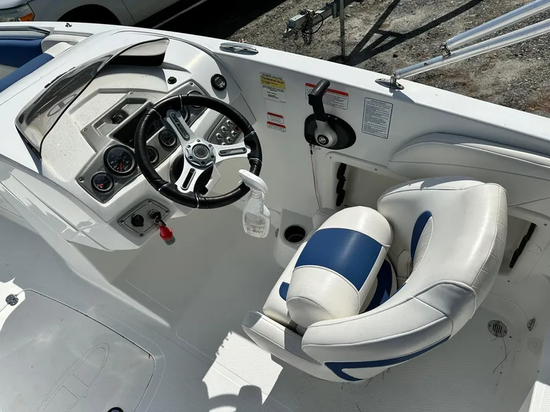 Slide: The Image of 2016 Tahoe 2150 Deck Boat cockpit with steering wheel and blue-white seating. - 5