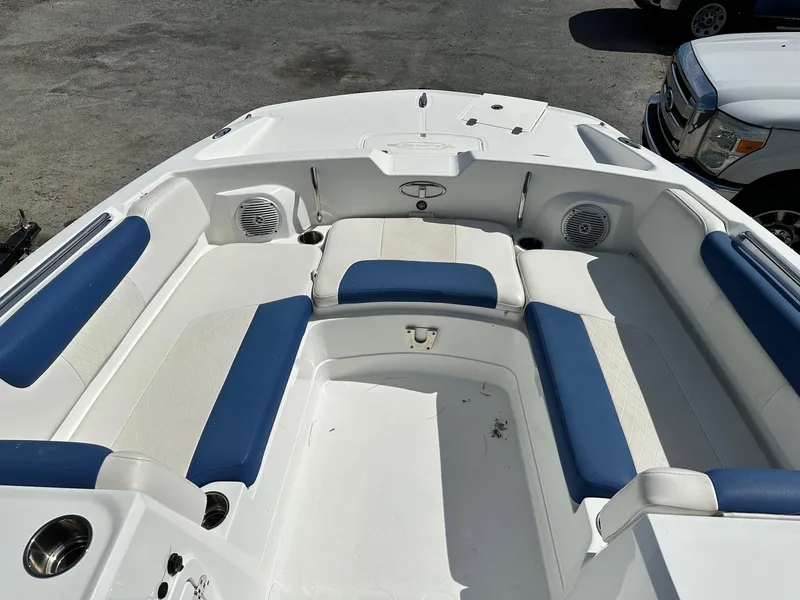 Slide: The Image of 2016 Tahoe 2150 Deck Boat interior with blue and white seating, cup holders, and speakers. - 8