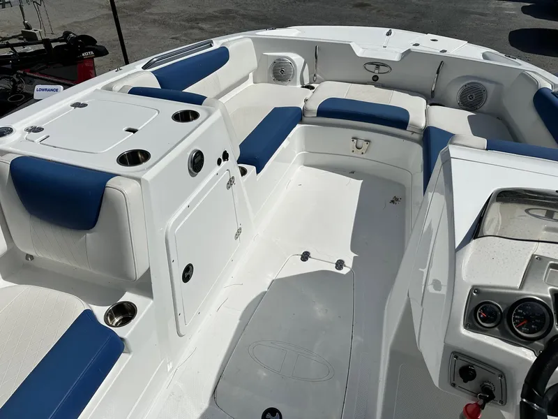 Slide: The Image of 2016 Tahoe 2150 Deck Boat interior with blue and white seating, cup holders, and control panel. - 9