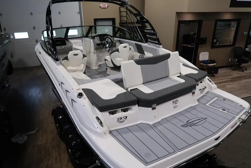 Slide: The Image of 2025 Chaparral 23 SSi boat with sleek design and spacious seating in showroom. - 12