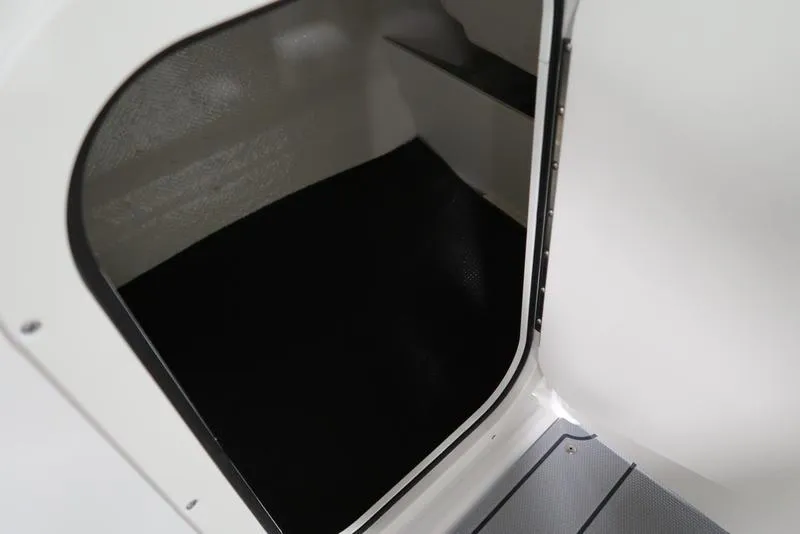 Slide: The Image of 2025 Chaparral 23 SSi boat interior storage compartment with black flooring. - 28