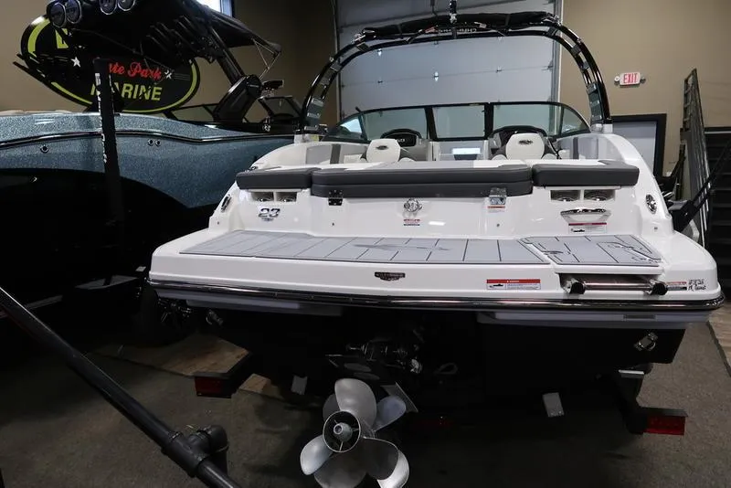Slide: The Image of 2025 Chaparral 23 SSi boat in showroom, rear view with propeller and seating. - 5
