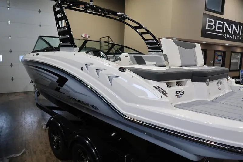 Slide: The Image of 2025 Chaparral 23 SSi boat in showroom, sleek design, white and gray color scheme. - 8