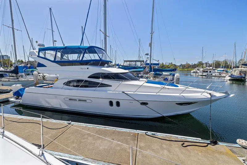 Slide: The Image of Luxury 2008 Dyna 51 yacht docked in a marina under clear blue skies. - 1