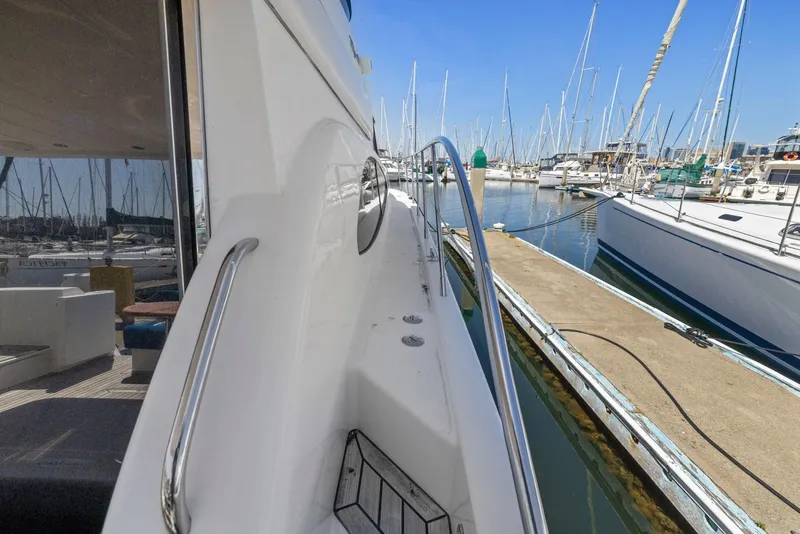 Slide: The Image of 2008 Dyna 51 yacht docked at marina, showcasing sleek design and polished railings. - 10