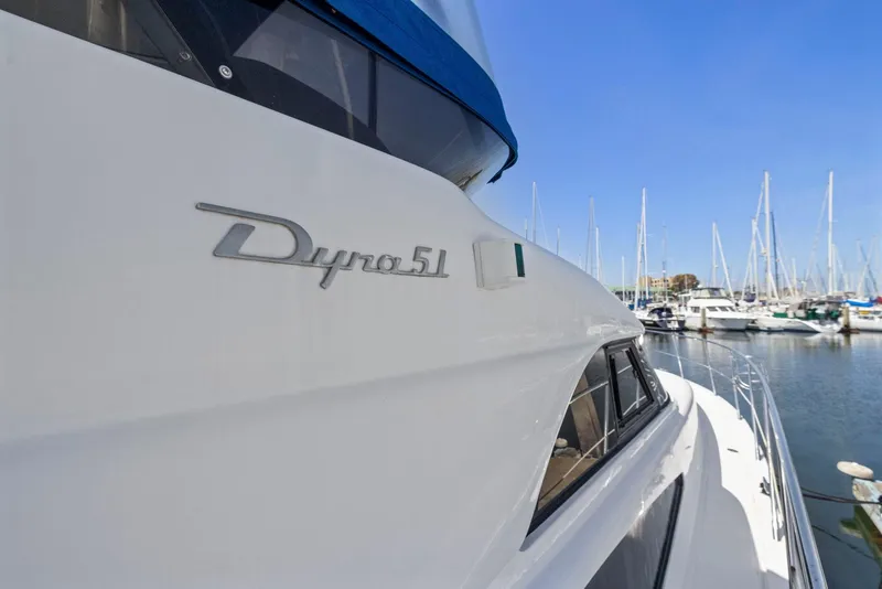 Slide: The Image of Luxury yacht Dyna 51, 2008 model, docked at marina with sailboats in background. - 11