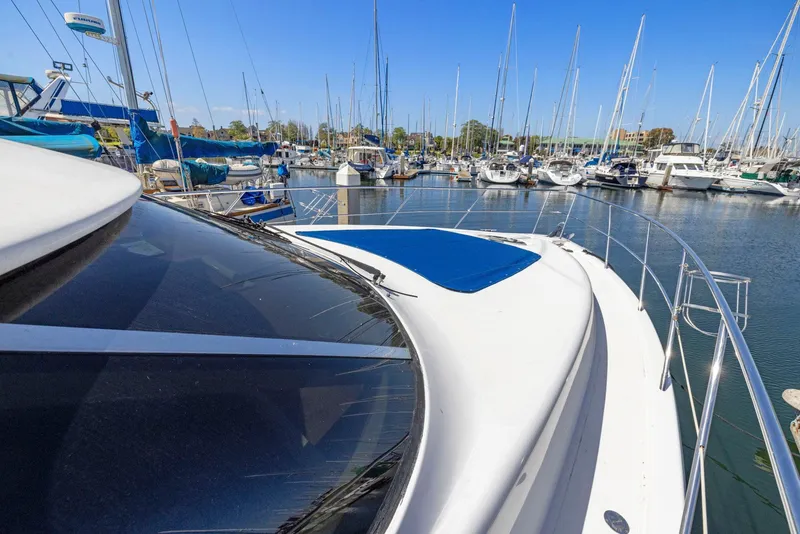 Slide: The Image of 2008 Dyna 51 yacht docked in a marina with other boats under clear blue sky. - 12