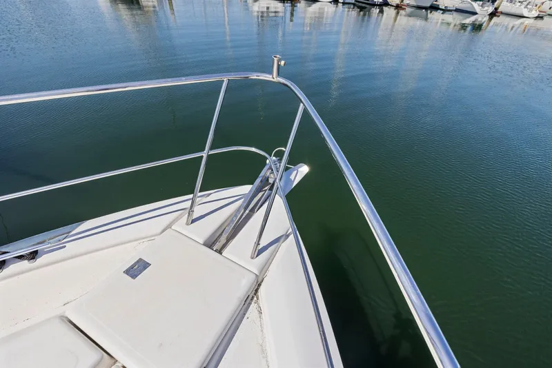 Slide: The Image of Bow of 2008 Dyna 51 yacht with stainless steel railing, docked in calm marina waters. - 13