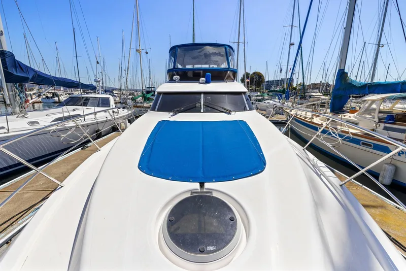 Slide: The Image of 2008 Dyna 51 yacht docked in marina, surrounded by sailboats under clear blue sky. - 14
