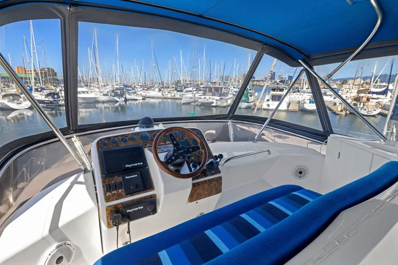 Slide: The Image of Cockpit view of 2008 Dyna 51 yacht with marina background and blue-striped seating. - 17