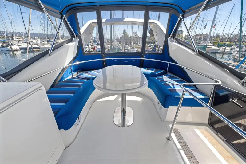Slide: The Image of 2008 Dyna 51 yacht interior with blue seating and table, docked at marina. - 22