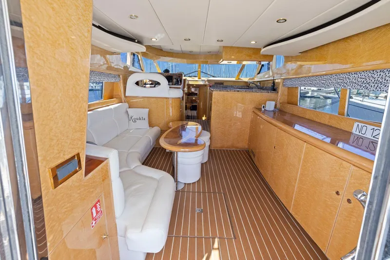 Slide: The Image of Luxurious interior of a 2008 Dyna 51 yacht with elegant wood and white leather seating. - 23