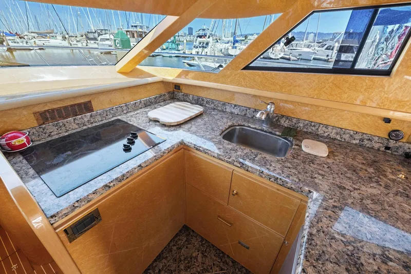 Slide: The Image of Luxurious kitchen area in a 2008 Dyna 51 yacht with granite countertops and marina view. - 33