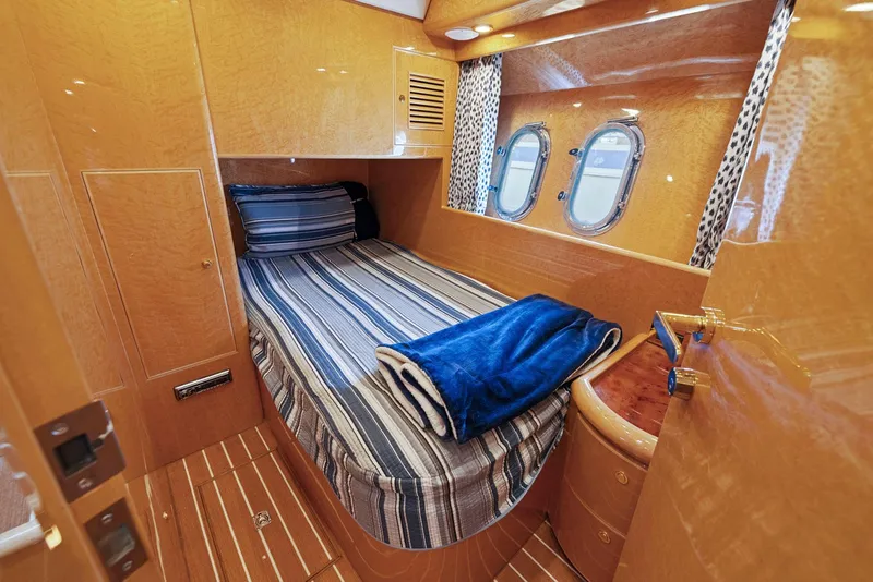 Slide: The Image of Luxurious cabin interior of 2008 Dyna 51 yacht with striped bedding and porthole windows. - 38