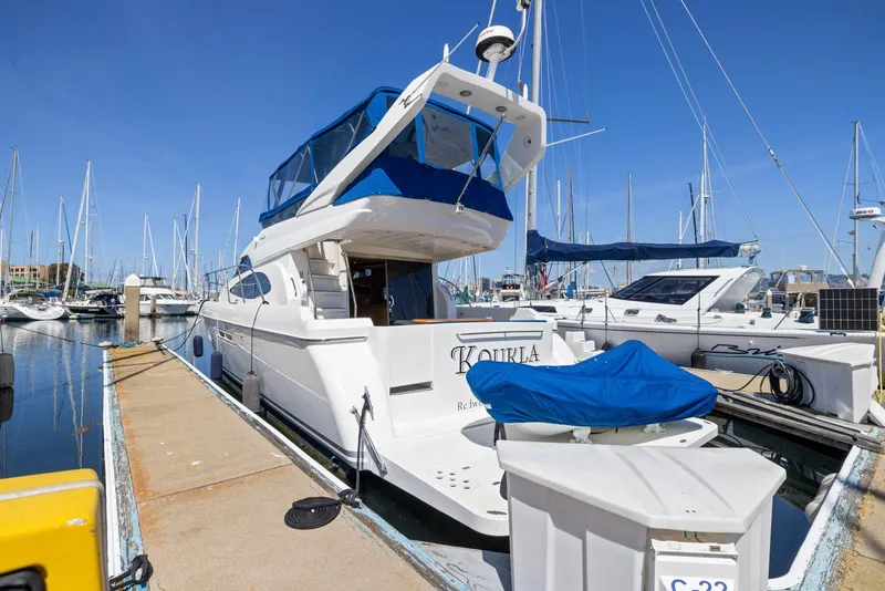 Slide: The Image of 2008 Dyna 51 yacht docked at marina, clear blue sky, other boats in background. - 4