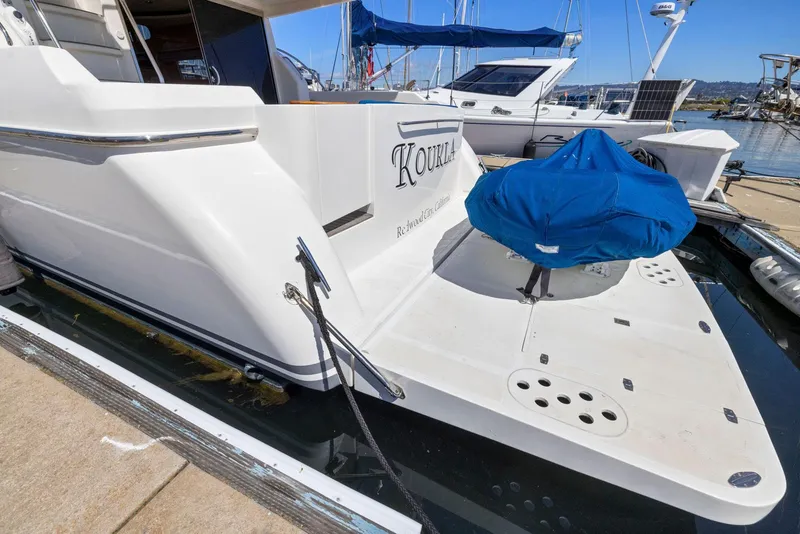 Slide: The Image of 2008 Dyna 51 yacht docked, featuring a spacious deck and covered equipment. - 5