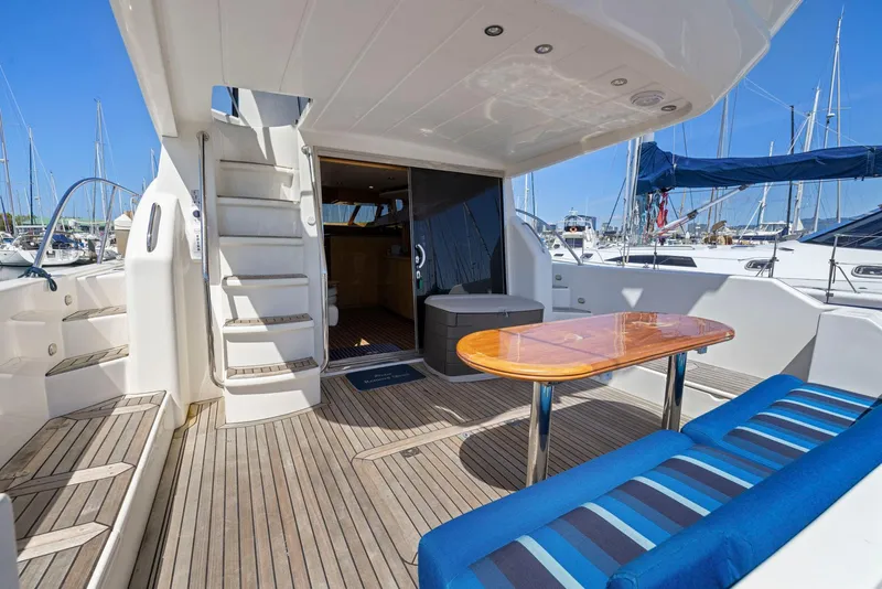 Slide: The Image of Luxurious 2008 Dyna 51 yacht deck with seating, table, and marina view. - 6