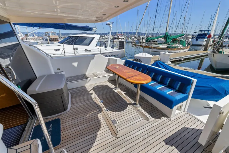 Slide: The Image of Spacious deck of 2008 Dyna 51 yacht with seating and table, docked at marina. - 7