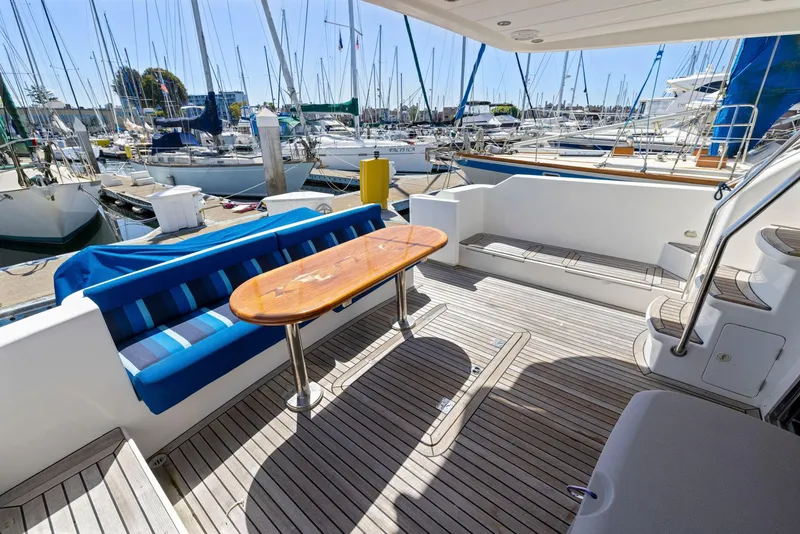 Slide: The Image of Spacious deck of 2008 Dyna 51 yacht with seating and table, docked at marina. - 8