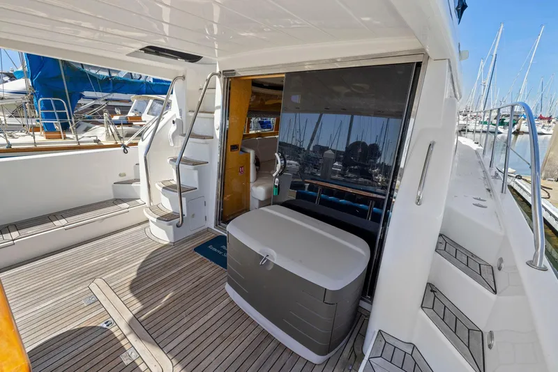 Slide: The Image of 2008 Dyna 51 yacht deck with stairs, seating, and marina view. - 9