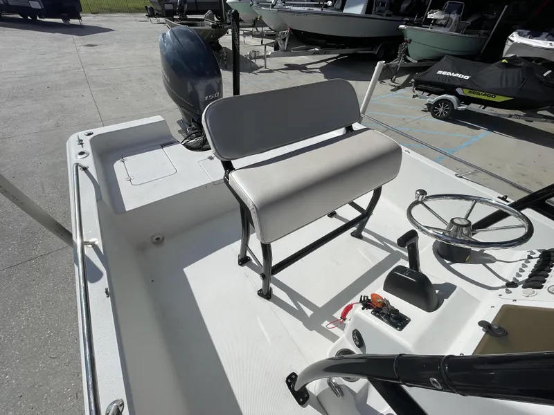 Slide: The Image of 2005 Sea Pro SV2100 boat interior with steering wheel and seating, parked outdoors. - 12