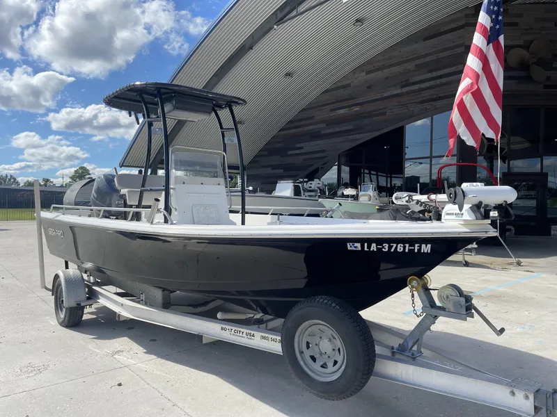 Slide: The Image of 2005 Sea Pro SV2100 boat on trailer, parked outside with American flag. - 2