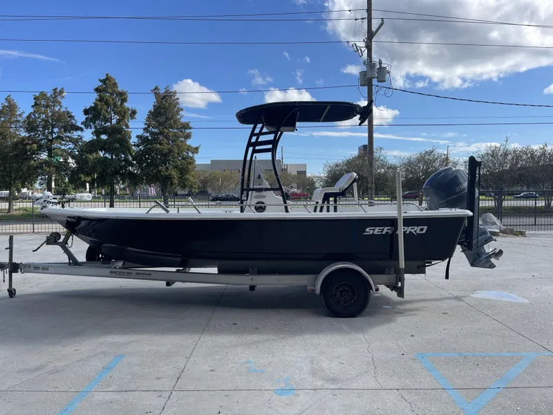 Slide: The Image of 2005 Sea Pro SV2100 boat on trailer, parked outdoors under a blue sky. - 6