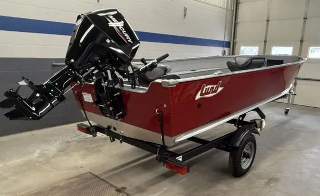 Slide: The Image of 2025 Lund 1600 Fury Tiller boat in a garage, featuring a red exterior and outboard motor. - 9