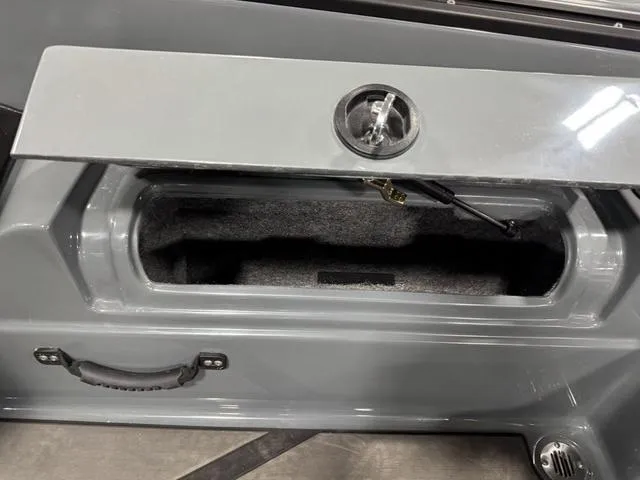 Slide: The Image of 2025 Lund 185 Impact GL Sport storage compartment with open lid and handle. - 15