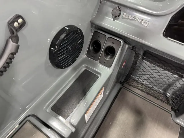 Slide: The Image of 2025 Lund 185 Impact GL Sport interior with speaker, cup holders, and storage net. - 17