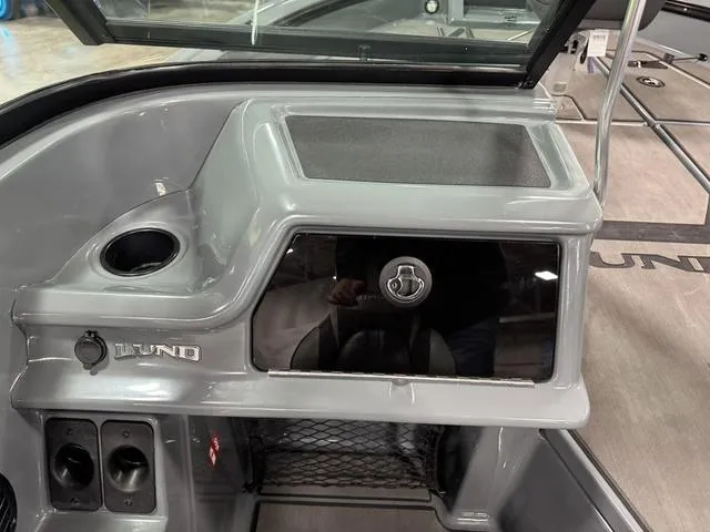 Slide: The Image of 2025 Lund 185 Impact GL Sport boat dashboard with storage compartment and cup holder. - 18