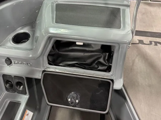 Slide: The Image of 2025 Lund 185 Impact GL Sport boat console with storage compartment open. - 19