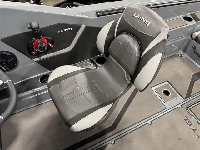 Slide: The Image of 2025 Lund 185 Impact GL Sport boat interior with gray and black seating. - 24