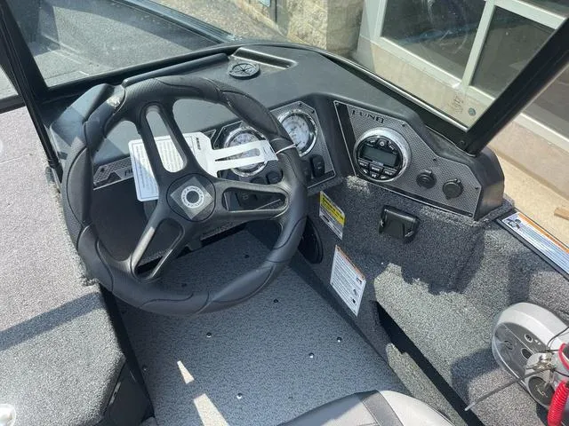 Slide: The Image of 2025 Lund 1775 Adventure Sport boat dashboard with steering wheel and gauges. - 6