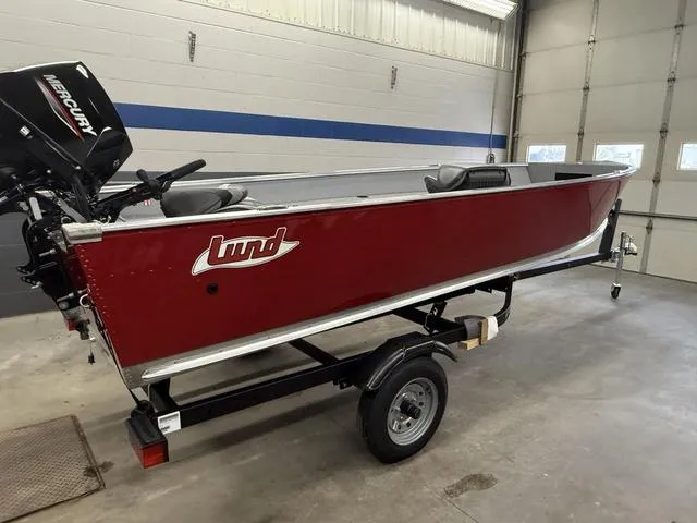 Slide: The Image of 2025 Lund 1600 Fury Tiller boat, red, on trailer in garage. - 3