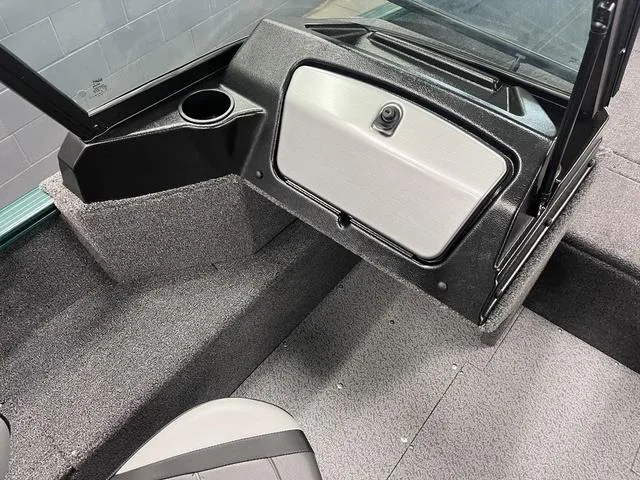 Slide: The Image of 2025 Lund 1650 Rebel XL Sport interior with storage compartment and cup holder. - 10