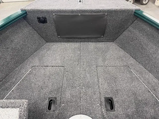 Slide: The Image of 2025 Lund 1650 Rebel XL Sport boat interior with carpeted flooring and storage compartments. - 11