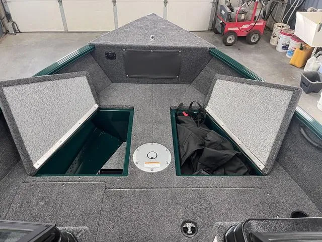 Slide: The Image of 2025 Lund 1650 Rebel XL Sport boat interior with open storage compartments in a garage. - 15