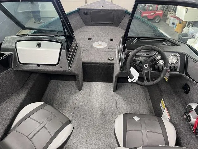Slide: The Image of 2025 Lund 1650 Rebel XL Sport boat interior with steering wheel and seating. - 18