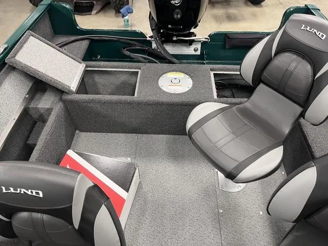 Slide: The Image of 2025 Lund 1650 Rebel XL Sport boat interior with gray seating and storage compartments. - 19