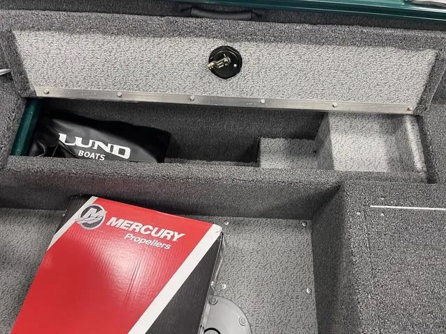 Slide: The Image of 2025 Lund 1650 Rebel XL Sport boat interior with Mercury propellers box and storage compartments. - 22