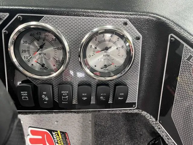 Slide: The Image of Dashboard of 2025 Lund 1650 Rebel XL Sport boat with gauges and control switches. - 24