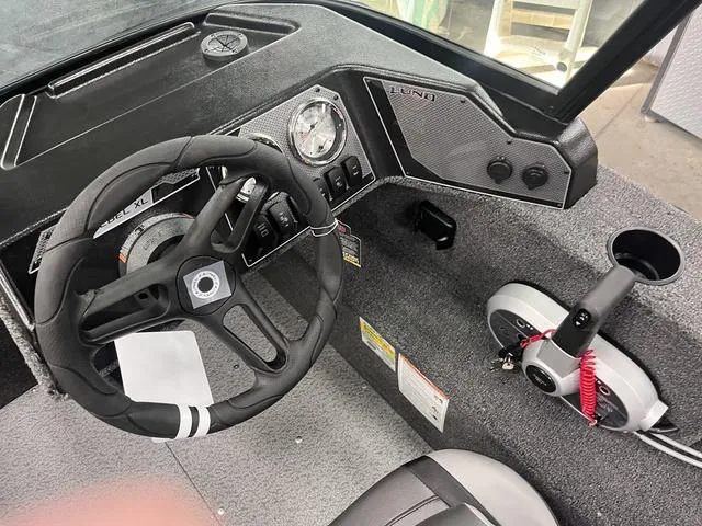 Slide: The Image of 2025 Lund 1650 Rebel XL Sport boat interior with steering wheel and control panel. - 25