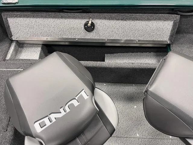 Slide: The Image of 2025 Lund 1650 Rebel XL Sport boat interior with gray seating and storage compartment. - 27