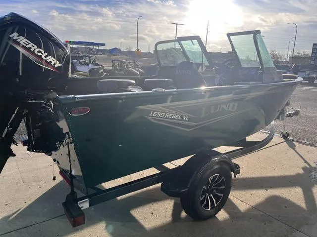 Slide: The Image of 2025 Lund 1650 Rebel XL Sport boat with Mercury engine on trailer, outdoors. - 4