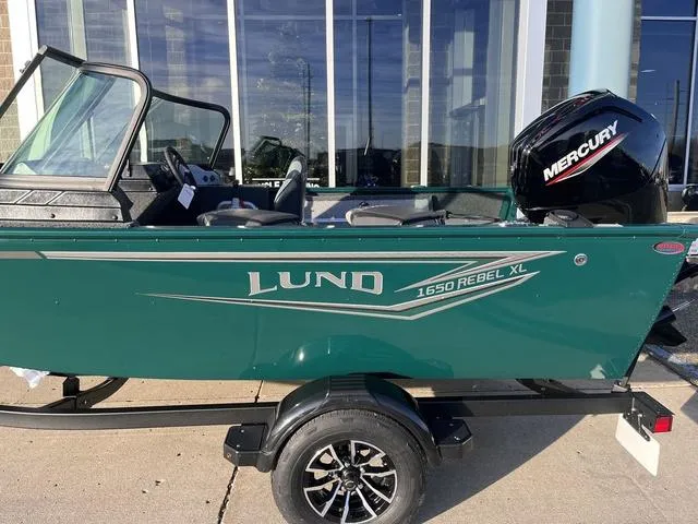 Slide: The Image of 2025 Lund 1650 Rebel XL Sport boat with Mercury engine, parked on a trailer. - 7