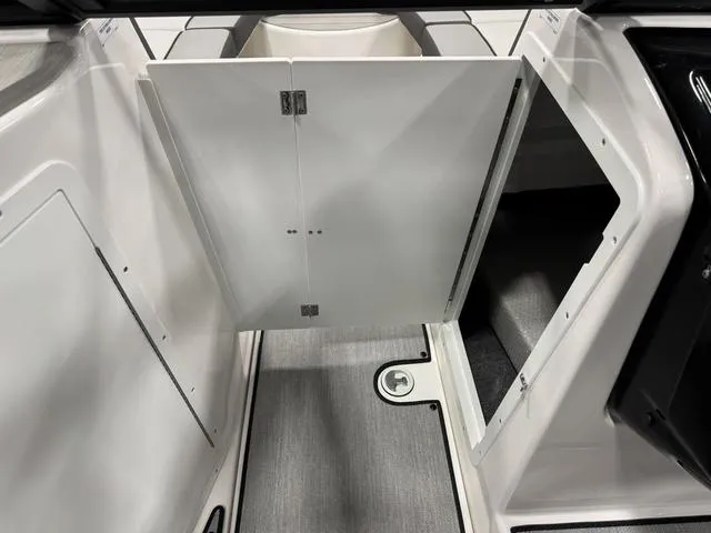 Slide: The Image of 2025 Yamaha Boats AR220 interior storage compartment with open doors, showcasing sleek design and functionality. - 11