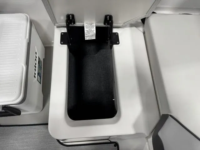 Slide: The Image of 2025 Yamaha Boats AR220 storage compartment with Igloo cooler nearby. - 15