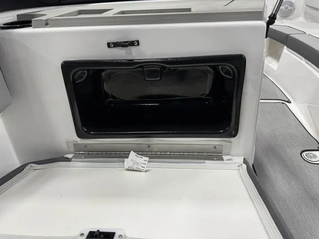 Slide: The Image of 2025 Yamaha Boats AR220 storage compartment with open hatch, showcasing interior space. - 17