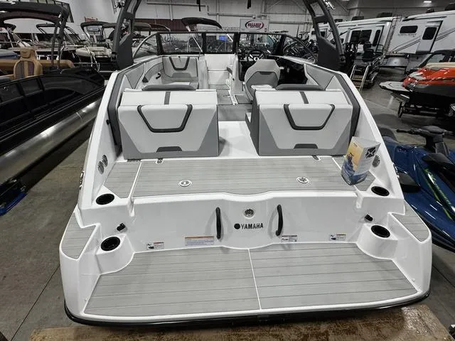 Slide: The Image of 2025 Yamaha Boats AR220, sleek white design, spacious seating, displayed indoors. - 3